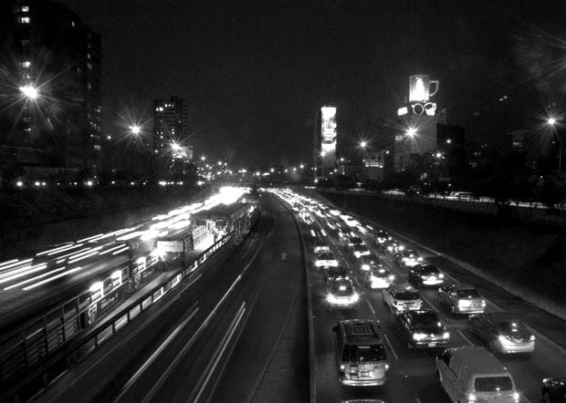 Estelas de luz del tráfico nocturno en una autopista, blanco y negro