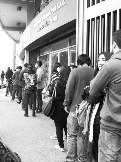 Personas haciendo fila en la calle, blanco y negro