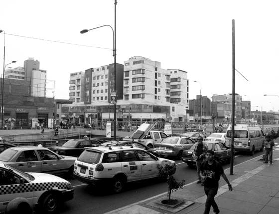Avenida con taxis y edificios al atardecer, blanco y negro